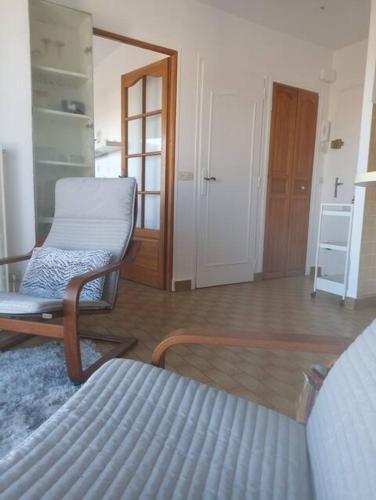 Cette chambre comprend un lit, une chaise et une porte. dans l'établissement La Terrasse - proche gare et centre ville, parking -, à Sète