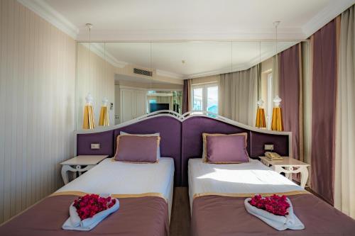 duas camas num quarto com roxo e branco em La Boutique Hotel & Suites em Antalya