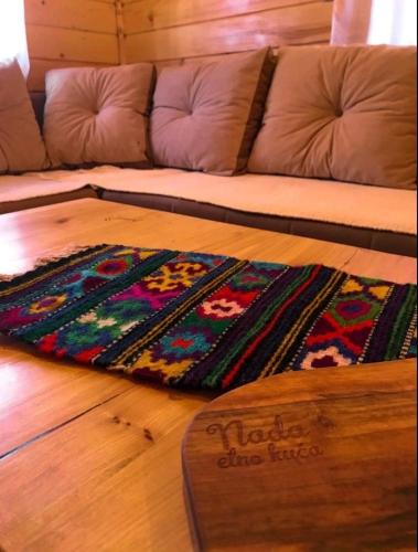 a rug on the floor in front of a couch at Etno kuća ''Nada'' in Jahorina