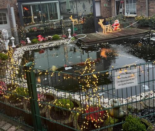 a house with a pond with christmas lights in it at Hotel zur Wasserburg in Kerpen