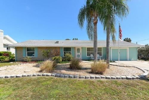 una casa con una palmera y una bandera en Pleasant Palms Home, en Holmes Beach