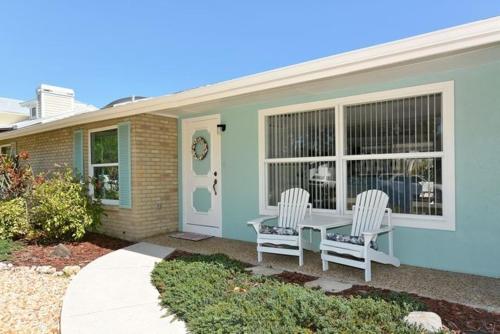 una casa con dos sillas y una mesa frente a ella en Pleasant Palms Home, en Holmes Beach
