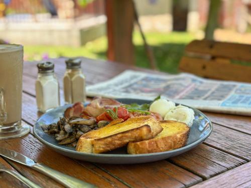 a plate of food on a table with toast and bread at Peel Inn Hotel Nundle in Nundle