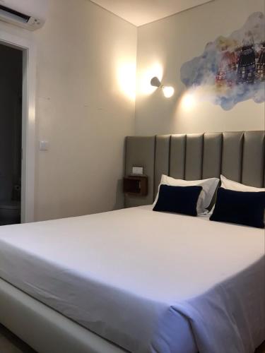 a large white bed with blue pillows in a room at Guest House Alojamento Local centro Ponte de Lima in Ponte de Lima