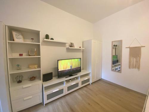 a living room with a television on a white entertainment center at Milano Holiday & Work House - Duomo in Milan