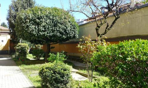 a garden with trees and bushes next to a building at Milano Holiday & Work House - Duomo in Milan