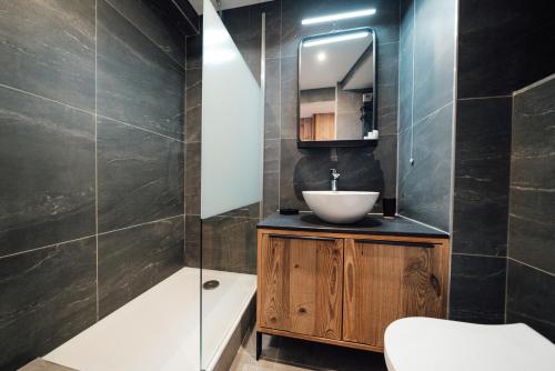 uma casa de banho com um lavatório e um espelho em Studio Interlude by ExplorHome em Tignes