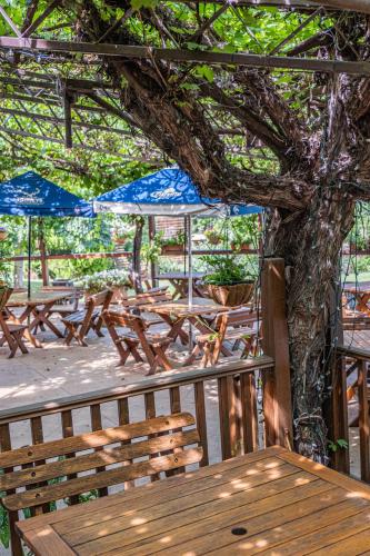a group of picnic tables and blue umbrellas on a deck at Peel Inn Hotel Nundle in Nundle