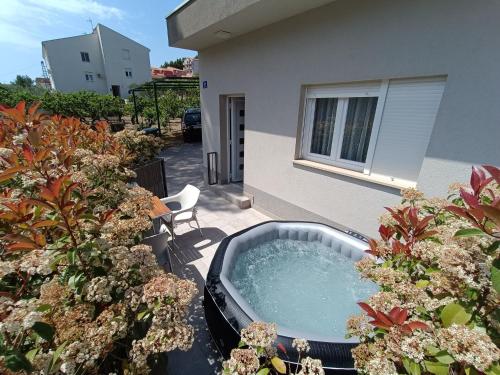 un bain à remous dans un jardin à côté d'un bâtiment dans l'établissement Holiday Home Relax, à Podstrana