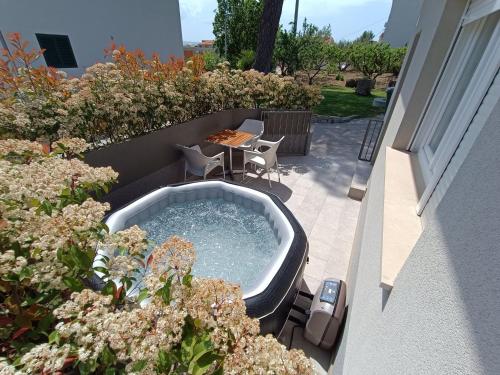 - un bain à remous sur une terrasse avec une table et des chaises dans l'établissement Holiday Home Relax, à Podstrana