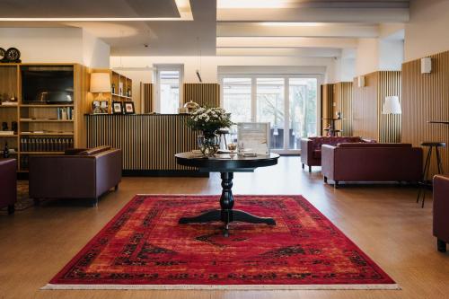 a living room with a table on a red rug at Ribeira Collection Hotel by Piamonte Hotels in Arcos de Valdevez