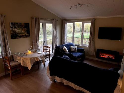 a living room with a couch and a table with a fireplace at The Lodge at Meadow Hope in Hereford