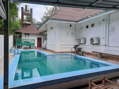 a pool in front of a house at Whitehouse cafe&Guesthouse in Ban Sa La