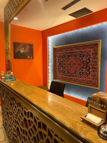 a bar in a restaurant with an orange wall at Hotel Ney in Konya
