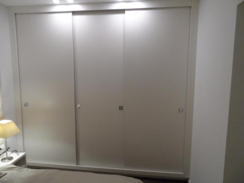 a large white cabinet in a bedroom with a bed at Erkel Rooftop Suites in Budapest