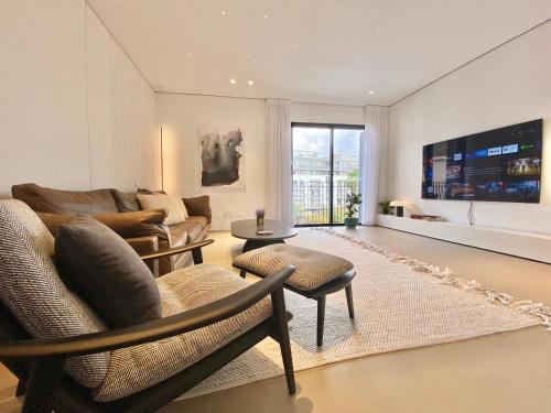 a living room with a couch and a table at 12 Shimon HaTzadik - By Beach Apartments TLV in Tel Aviv