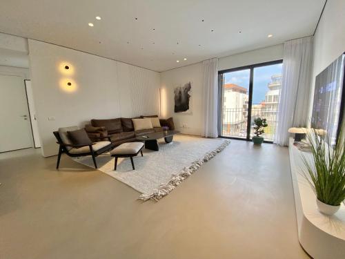 a living room with a couch and a table at 12 Shimon HaTzadik - By Beach Apartments TLV in Tel Aviv