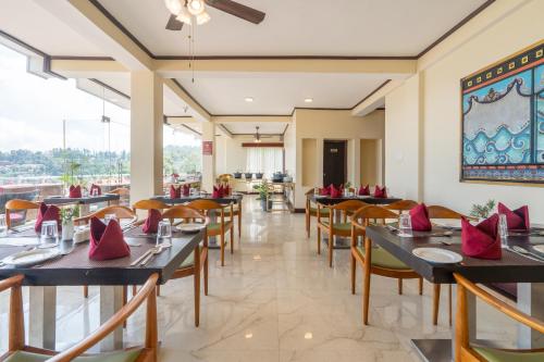 a restaurant with tables and chairs with red pillows at Summit Lillium Hotel & Spa in Kalimpong