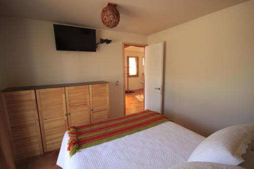a bedroom with a bed and a flat screen tv at Hotel El Bramador in Copiapó