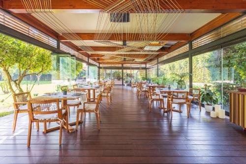 un restaurante con mesas, sillas y ventanas en Hotel Rural Xereca en Puig D’en Valls