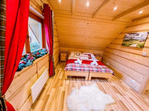 a small room with a bed in a wooden cabin at Domek Góralski zakątek Czerwienne in Czerwienne
