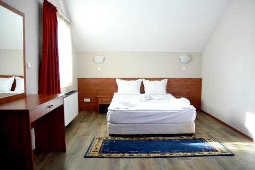 a bedroom with a white bed and a red curtain at Sveta Sofia Hotel in Sofia
