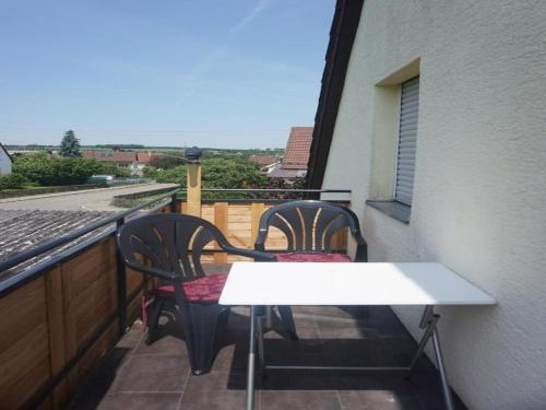 dwa krzesła i biały stół na balkonie w obiekcie Ferienwohnung Kirsch-Kern w mieście Mössingen