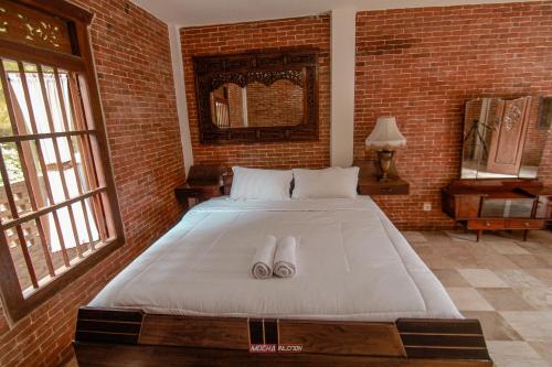 a bedroom with a bed with two slippers on it at Joglo Kecombrang Bromo in Ngadisari