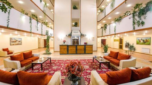 a large lobby with couches and a large rug at Reikartz Dostar Karaganda in Karagandy