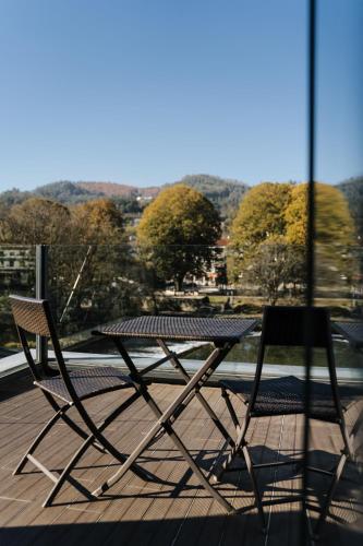 a table and two chairs sitting on a deck at Ribeira Collection Hotel by Piamonte Hotels in Arcos de Valdevez