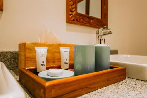 a wooden tray with two candles and a sink in a bathroom at Kivuli Beach Resort Paje in Paje