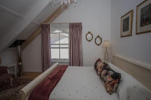 um quarto com uma cama grande e uma janela em Riverside Country House em Swellendam