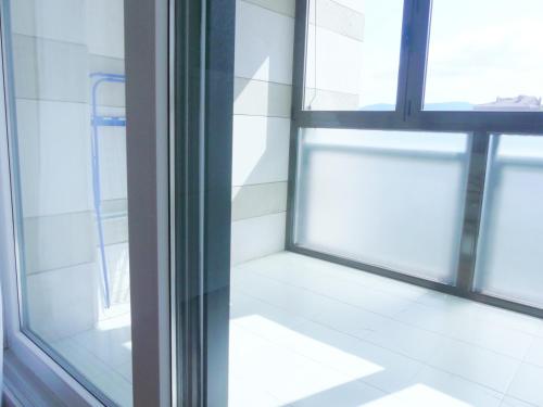 een lege kamer met een raam en een witte tegelvloer bij Apartamento luminoso, funcional y amplio en zona hospitalaria in Pamplona