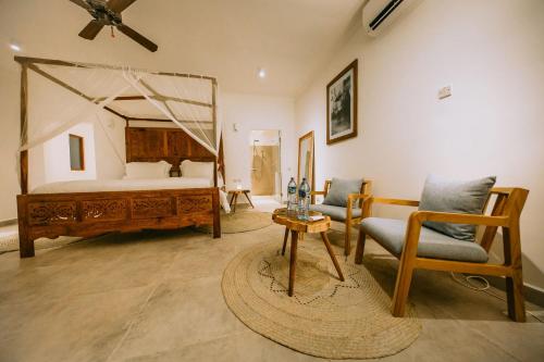 1 dormitorio con 1 cama, 1 silla y 1 mesa en Kivuli Beach Resort Paje en Paje