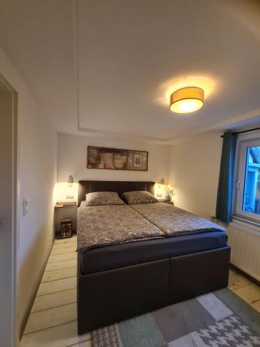 1 dormitorio con 1 cama en una habitación con ventana en Möwenstübchen, en Zingst
