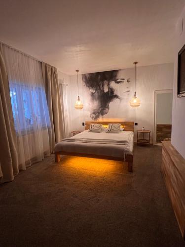 a bedroom with a bed and a painting on the wall at Shard Boutique Hotel-adult only in Braşov