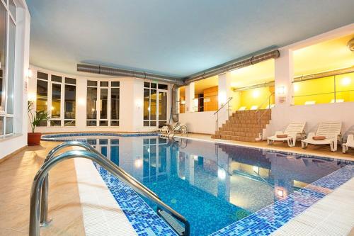 a swimming pool with stairs and chairs and a swimming pool at Спа,ски апартамент Дайли, Стрийм Ризорт Пампорово in Pamporovo