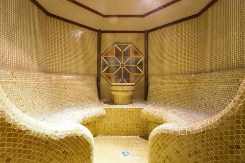 a tiled room with a toilet in the middle at Спа,ски апартамент Дайли, Стрийм Ризорт Пампорово in Pamporovo