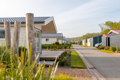 a park bench in front of a row of houses at Strandcamping Valkenisse in Biggekerke