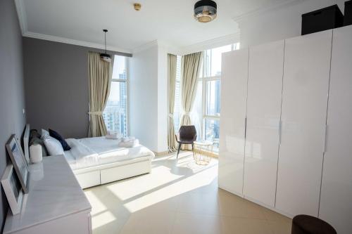 a white bedroom with a bed and a large window at WSuites - Big Terrace with Beautiful Marina View in Dubai