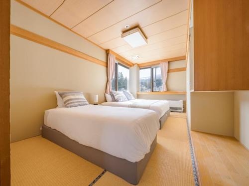 a large bedroom with two beds in a room at Red Fox Lodge Myoko in Myoko
