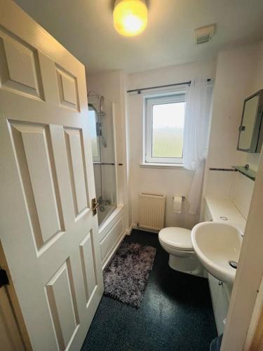a bathroom with a white toilet and a sink at Lovely entire 2 Bedroom apartment in Monifieth