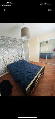 a bedroom with a bed with a blue comforter at Lovely entire 2 Bedroom apartment in Monifieth