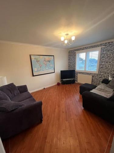 a living room with a couch and a television at Lovely entire 2 Bedroom apartment in Monifieth