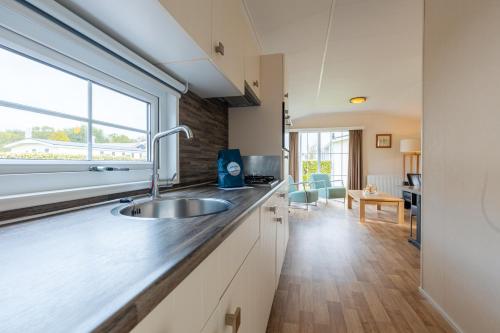 a kitchen with a sink and a window at Strandcamping Valkenisse in Biggekerke