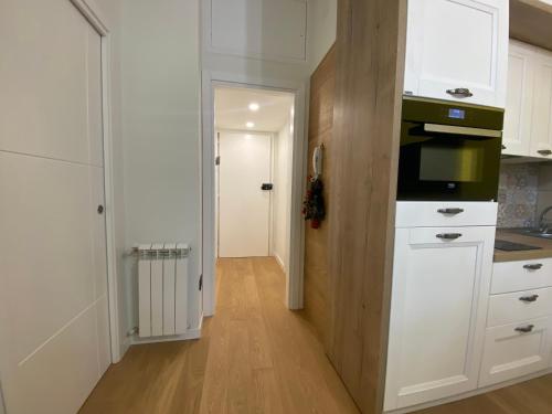 uma cozinha com armários brancos e um micro-ondas em Sendy Home Roccaraso 3 em Roccaraso