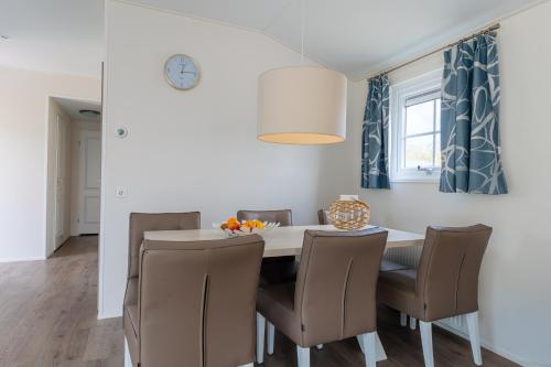 a dining room with a table and chairs at Strandcamping Valkenisse in Biggekerke