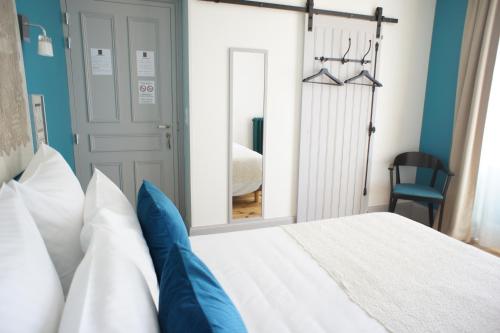 a bedroom with a white bed and a mirror at MAS TERRE Chambres d'Hôtes in Lezoux