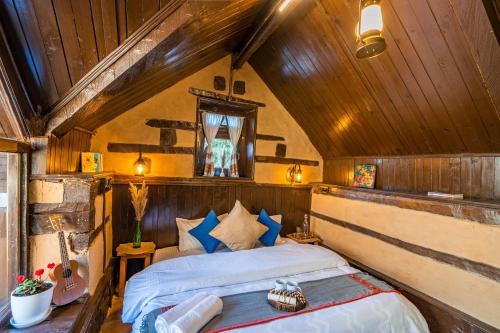 a bedroom with a bed in a room with wooden ceilings at Zostel Homes Laida (Jibhi) in Sainj
