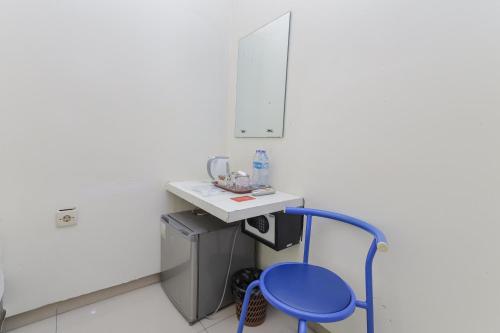 泗水的住宿－RedDoorz Plus At K23 Rungkut Madya，房间里的水槽旁边有一个蓝色凳子